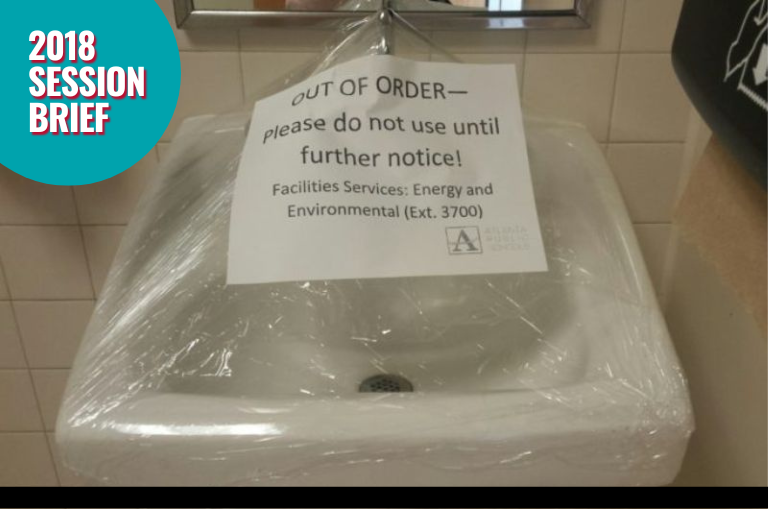 sink wrapped in plastic with out of order signage